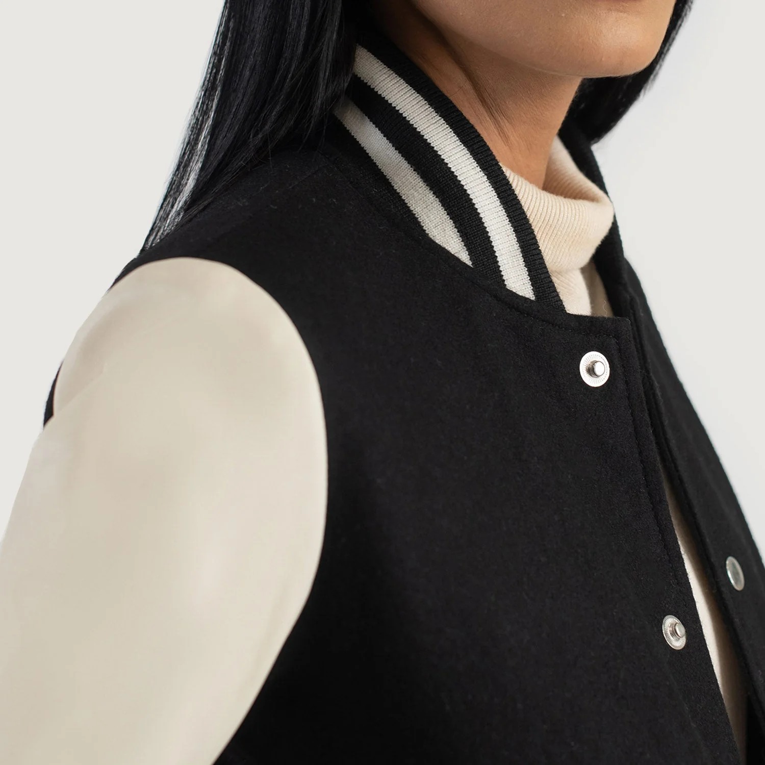 A detailed view of a custom leather varsity jacket women's featuring a tailored fit, butter-soft sheepskin leather sleeves, and premium wool body.