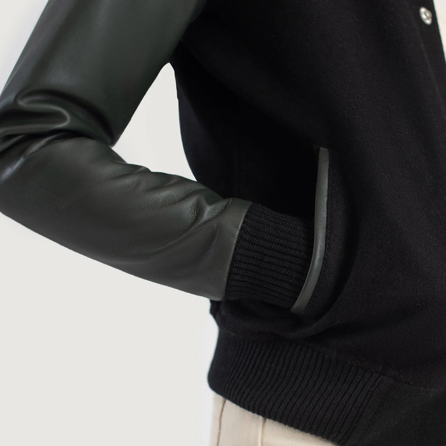 A detailed view of a custom leather varsity jacket women's featuring a tailored fit, butter-soft sheepskin leather sleeves, and premium wool body.