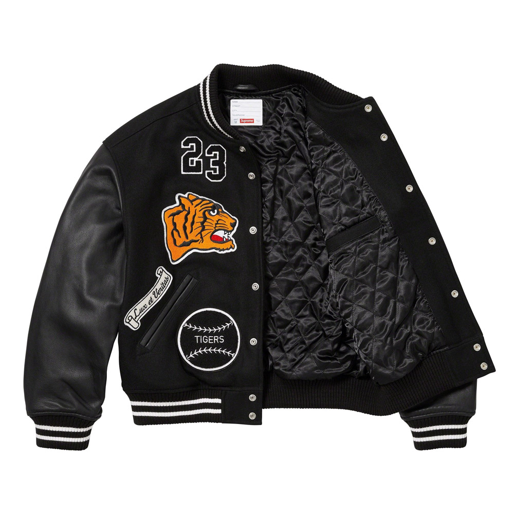 A detailed view of a custom Supreme varsity jacket featuring a premium melton wool body, genuine cowhide leather sleeves, and high-density chenille branding.