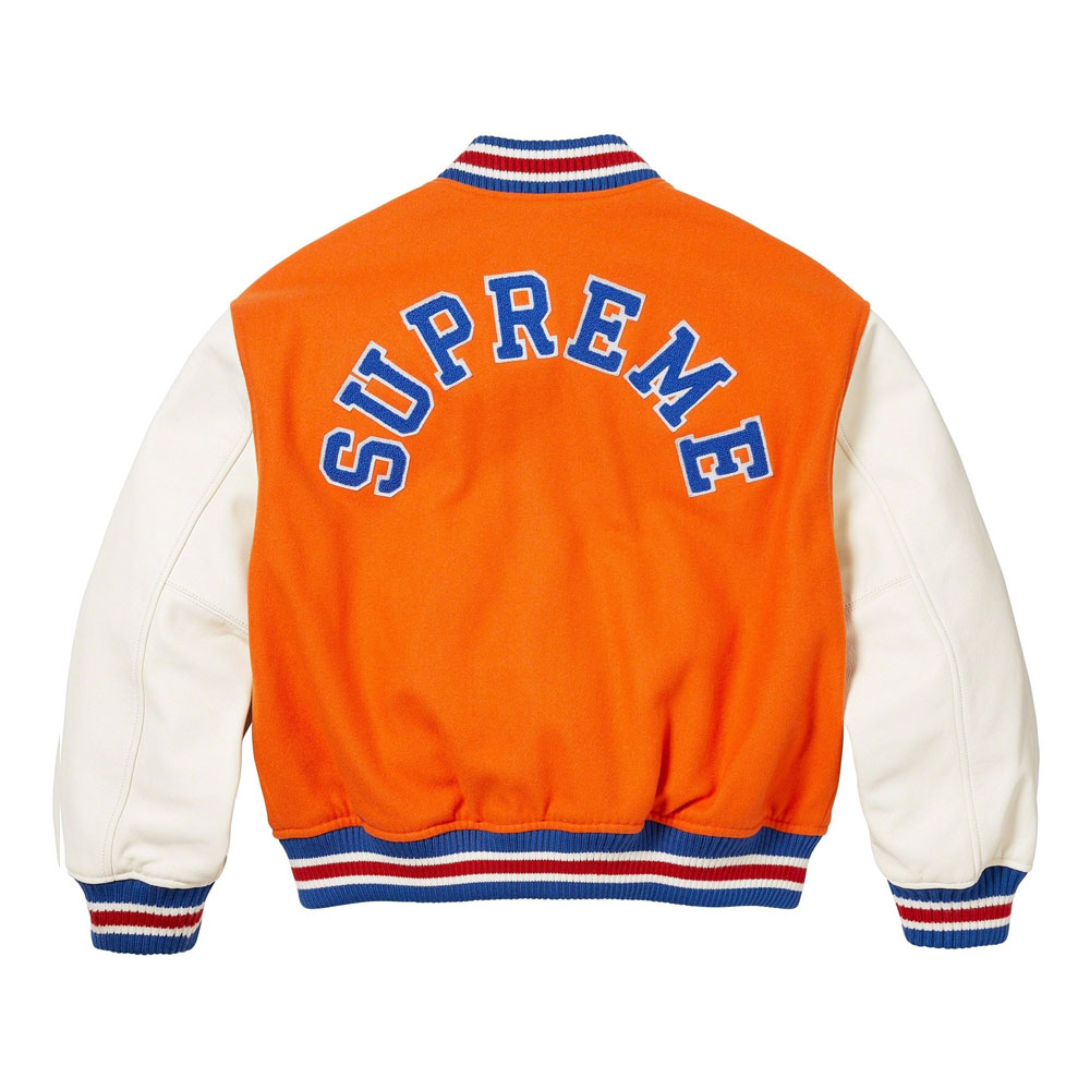 A detailed view of a custom Supreme varsity jacket featuring a premium melton wool body, genuine cowhide leather sleeves, and high-density chenille branding.