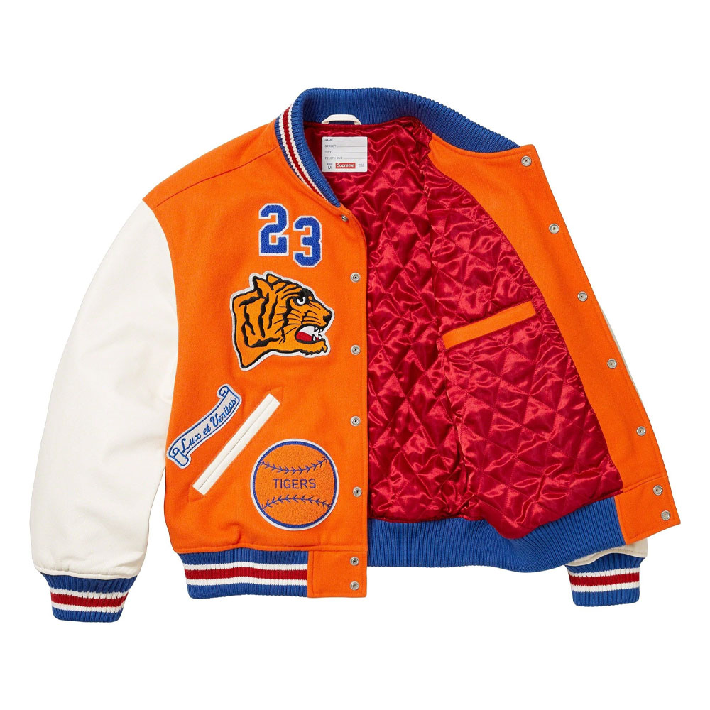 A detailed view of a custom Supreme varsity jacket featuring a premium melton wool body, genuine cowhide leather sleeves, and high-density chenille branding.